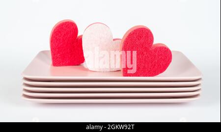 Pink plates and red and pink dish, kitchen sponges in heart shape Stock Photo