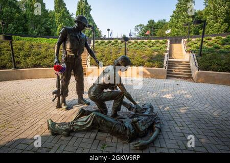 Bronze statues at the New Jersey Vietnam Veterans’ Memorial at Holmdel, N.J., July 7, 2021. The statues represent those who came home, the women who served, and those who did not return. The Memorial, an open-air circular pavilion measuring 200 feet in diameter, was designed by Hien Nguyen, who came to the United States from Vietnam in 1975. It is comprised of 366 eight-foot-tall black granite panels, each representing a day of the year. Casualties are listed on the granite panels on the day they were killed. The May seventh panel, the day the war ended, is oriented toward Vietnam. The Memoria Stock Photo
