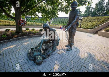 Bronze statues at the New Jersey Vietnam Veterans’ Memorial at Holmdel, N.J., July 7, 2021. The statues represent those who came home, the women who served, and those who did not return. The Memorial, an open-air circular pavilion measuring 200 feet in diameter, was designed by Hien Nguyen, who came to the United States from Vietnam in 1975. It is comprised of 366 eight-foot-tall black granite panels, each representing a day of the year. Casualties are listed on the granite panels on the day they were killed. The May seventh panel, the day the war ended, is oriented toward Vietnam. The Memoria Stock Photo