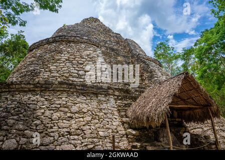 Nohoch Mul Pyramid and temple with straw roof in the Maya ruins of Coba Stock Photo