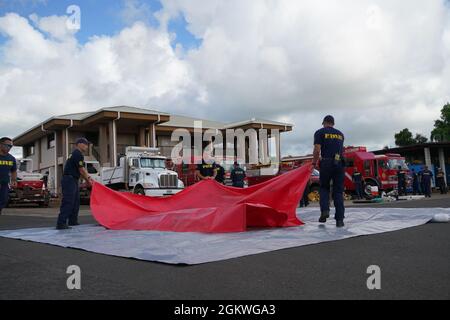 Fire Fighters with the Kauai Fire Department practice setting up a decontamination area outside a hazardous material environment, Kauai, Hawaii, July 09, 2021. The Hawaii National Guard 93rd WMD-CST conducted joint training with Kauai emergency response agencies including the Kauai Fire Department, Kauai Police Department and Hawaii Department of Health to refine and enforce the Hawaii counties response interoperability in a natural or man-made Hazardous Material (HAZMAT) or Chemical, Biological, Radiological, Nuclear (CBRN) incident. Stock Photo