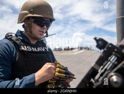 EAST CHINA SEA (July 10, 2021) Retail Specialist 3rd Class Christian Shields, from Stuart, Fla., reloads a .50 cal. machine gun during a crew-serve weapon familiarization aboard Arleigh Burke-class guided-missile destroyer USS John S. McCain (DDG 56). McCain is assigned to Task Force 71/Destroyer Squadron (DESRON) 15, the Navy’s largest DESRON and the U.S. 7th Fleet’s principal surface force. Stock Photo