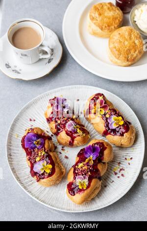 Afternoon tea with eclairs and scones Stock Photo