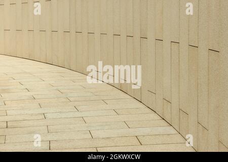 Fragment of footpath and wall paved with granite slabs Stock Photo