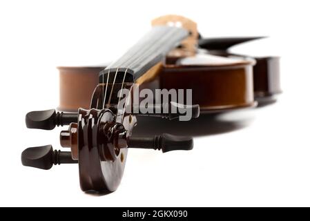 Focus on scroll and pegs of violin. Focus on the scroll and the violin pegs. The violin body is blurred. Isolated on white, copy space. Stock Photo