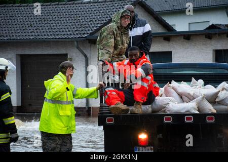 Members from the 52nd Civil Engineer Squadron from Spangdahlem Air Base, Germany, work with German first responders and community members to deliver sandbags to the town of Binsfeld, Germany, July 14, 2021. The 52 CES was able to fill and deliver around 1,800 sandbags to help protect homes and businesses in the communities of Binsfeld and Neiderkail after heavy rainfall caused severe flooding in the region. Stock Photo