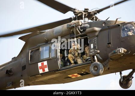 U.S. Army Soldiers assigned to 3rd Forward Support Medical Platoon, 2nd General Support Aviation Battalion, 1st Combat Aviation Brigade, Task Force Nightmare, reset a hoist after using it to evacuate a patient during a multi-day MEDEVAC training exercise at Novo Selo Training Area, Bulgaria on July 14, 2021. Our ability to quickly respond and reassure allies and partners rests upon the fact that we are here, in Europe, forward and ready. Stock Photo