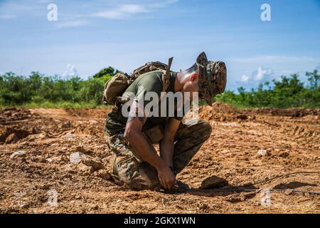 U.S. Marine Corps Sgt. Alexander Moore, an explosive ordnance disposal technician with 3d EOD Company, 9th Engineer Support Battalion, 3d Marine Logistics Group, secures a blasting cap and detonation cord to wire attached to a receiver during an EOD operation on Range 10, Camp Schwab, Okinawa, Japan, July 14, 2021. Marines with 3d EOD Co. and Alpha Co. conducted EOD operations simulating the discovery and disposal of notional foreign unexploded ordnance. 3d MLG, based out of Okinawa, Japan, is a forward deployed combat unit that serves as III Marine Expeditionary Force’s comprehensive logistic Stock Photo