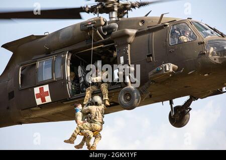 Staff Sgt. Timothy Thomas, a flight paramedic assigned to 3rd Forward Support Medical Platoon, 2nd General Support Aviation Battalion, 1st Combat Aviation Brigade, Task Force Nightmare, is lowered down on a hoist in order to retrieve a simulated patient during a MEDEVAC training exercise at Novo Selo Training Area, Bulgaria on July 14, 2021. Total readiness encompasses training, equipment and personnel and maintaining that readiness reassures our allies and deters potential adversaries. Stock Photo