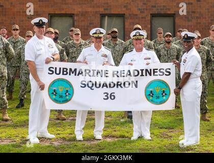 KINGS BAY, Ga., (July 15, 2021) From left to right: Command Master Chief Ed Rathgeber, Submarine Group Ten; Rear Adm. John Spencer, commander, Submarine Group Ten; Cmdr. Ron Allen, commanding officer; and Command Master Chief Mike Leggett pose with a banner in front of the staff at a ceremony changing the name of Commanding Officer, Naval Submarine Support Center Kings Bay to Commanding Officer, Submarine Readiness Squadron (SRS) 36, in Kings Bay, Georgia, July 15. The name change is in alignment with the submarine community's mission to generate combat ready submarines to meet mission tasking Stock Photo