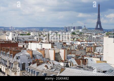 PARIS, FRANCE -8 JUL 2021- View of the roofs of Paris and the Eiffel Tower in the background seen from the top of the Printemps department store build Stock Photo