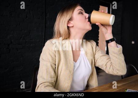 Woman drinks coffee from paper cup Stock Photo