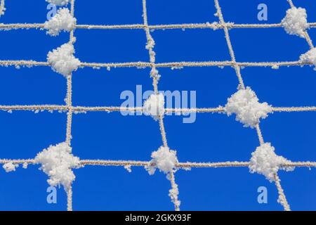 Volleyball net covered with snow. Nature's minimalism.  Stock Photo