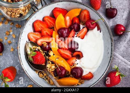 Healthy breakfast with granola, yogurt, fresh berries and coffee Stock Photo