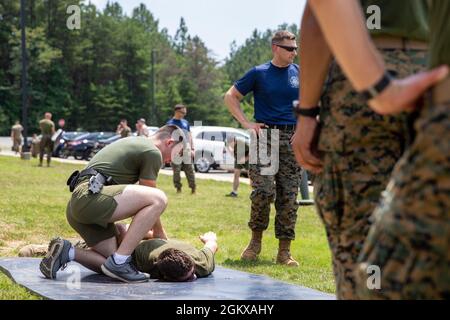 A U.S. Marine attached to Marine Corps Embassy Security Group handcuffs a student during oleoresin capsicum (OC) spray at Marine Corps Base Quantico, Virginia, July 15, 2021. Students are sprayed with OC as a part of their training to become Marine security guards. Stock Photo