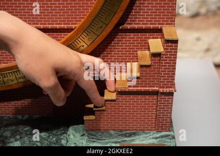 Closeup shot of a man's hand going up with the small toy stairs with his fingers Stock Photo