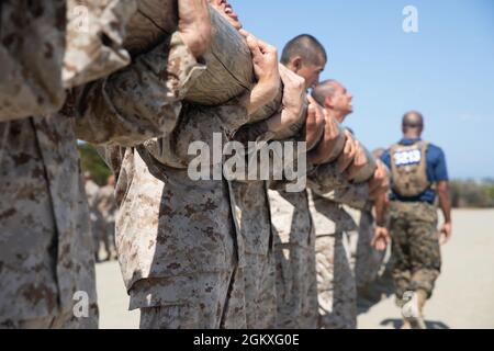 U.S. Marine Corps Recruits with India Company, 3rd Recruit Training Battalion, curl a log during log drills at Marine Corps Recruit Depot, San Diego, July 19, 2021. Physical training was utilized to strengthen the body and develop a strong character embodying our core values through teamwork. Stock Photo