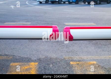 Closed barrier on carpark. Two white and red staves and asphalt with white and yellow road markings. borders closed. No entry pandemic concept. Closed Stock Photo