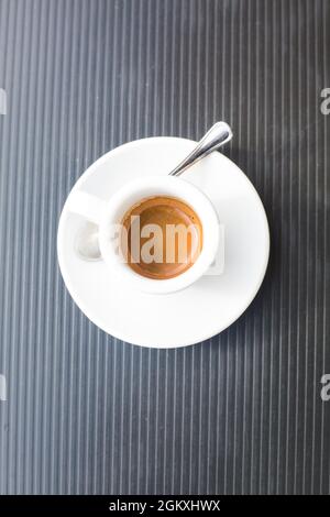 coffee couple with hot fresh espresso and metal tea spoon on grey plastic surface. Vertical geometrical composition. Top view to traditional italian Stock Photo