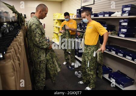 Senior Chief Gas Turbine Systems Technician Juan Rosa, a Recruit Division Commander (RDC) assigned to Officer Training Command Newport (OTCN), Rhode Island, observes an Officer Development School (ODS) class 21070 student test fit the Navy Working Uniform during an initial uniform issue, July 20. ODS provides staff corps officers and several restricted line designators with training necessary to prepare them to function in their role as newly commissioned Naval officers. Stock Photo