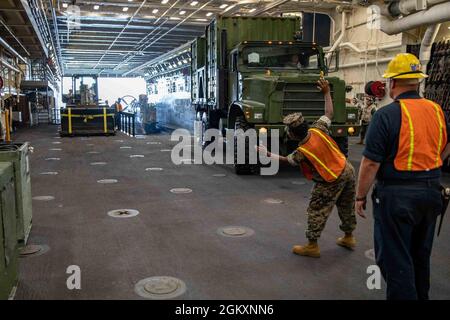 210721-N-PC065-1009 NORFOLK, Va. (July 21, 2021) Lance Cpl. Zandria Smith, assigned to Combat Logistics Battalion (CLB) 22, directs a vehicle through the well deck of the San Antonio-class amphibious transport dock ship USS Arlington (LPD 24) during a pierside loading exercise, July 21, 2021. Arlington is homeported in Norfolk, Virginia. Stock Photo