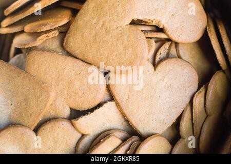 Traditional ginger bread biscuits in form of heart. Background or wallpaper in love topic. Saint Valentines sweet hearts. Bakery for tea. Many shaped Stock Photo