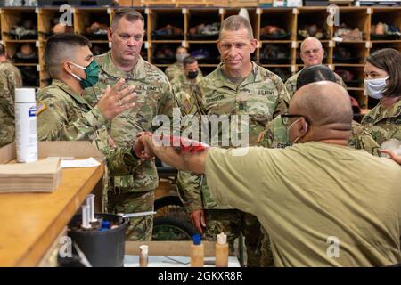 Spc. Javier Cosme, an Army mental health specialist for the 335th Medical Company, 332nd Medical Brigade, 3rd Medical Command, left, describes the process of preparing a simulated burn wound to Sergeant Major of the Army Michael A. Grinston, right, July 21, 2021, on Fort McCoy, Wis. The 335th Med. Co., is providing realistic training props and injects for units training during Pershing Strike 21. Stock Photo