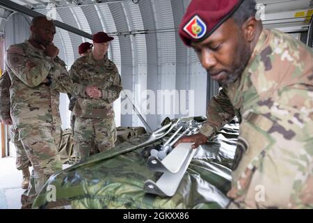 Staff Sgt. Joshua D. Carrington, lead jumpmaster with the 4th Infantry Brigade Combat Team (Airborne), 25th Infantry Division, US Army Alaska, demonstrates how paratroopers prepare their skis for airborne operations to Maj. Gen. Xavier T. Brunson (left), commander of I Corps, Washington, at Joint Base Elmendorf-Richardson, July 22, 2021. Brunson visited the 4th IBCT (ABN), 25th ID to discuss the strengths and weaknesses of the Army’s only airborne Arctic brigade as they focus on operations in Arctic environments. Stock Photo