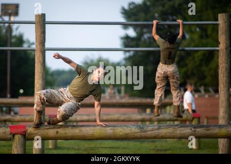 A U.S. Marine Corps officer candidate with Lima Company participates in the obstacle course at Officer Candidate School on Marine Corps Base Quantico, Virginia, July 22, 2021. The purpose of the Obstacle Course is to test the candidate’s ability to negotiate obstacles using the correct techniques while displaying a high level of agility, muscular strength, and stamina. Stock Photo