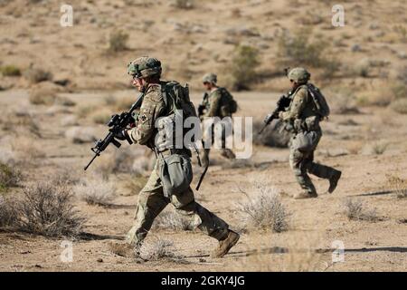 Soldiers with the 45th Infantry Brigade Combat Team, Oklahoma Army National Guard,  move through the desert during a live-fire exercise at the National Training Center in Fort Irwin, California, July 24, 2021. Members of the 45th IBCT participated in a live fire exercise in the mountains of the Mojave Desert with the intention of increasing their proficiency. Stock Photo