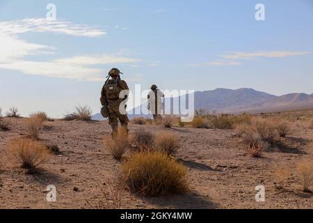 Soldiers with the 45th Infantry Brigade Combat Team, Oklahoma Army National Guard, move through the desert during a live-fire exercise at the National Training Center in Fort Irwin, California, July 24, 2021. Members of the 45th IBCT participated in a live fire exercise in the mountains of the Mojave Desert with the intention of increasing their proficiency. Stock Photo