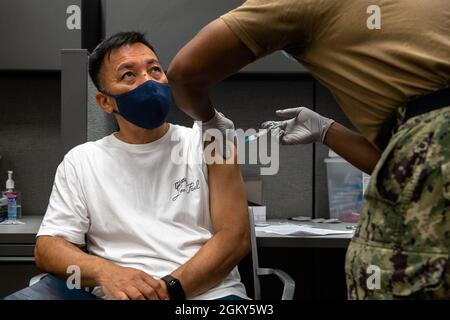 A master labor contractor with Marine Corps Installations Pacific receives his COVID-19 vaccination at the U.S. Naval Hospital Okinawa on Camp Foster, Okinawa, Japan, July 26, 2021. Vaccinating host-nation employees and military personnel will contribute to the prevention of further spread of COVID-19 in Japan and will protect the resilience of the alliance. Stock Photo