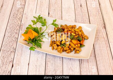 Delicious plate of kung pao chicken with nuts, pickled corn, Chinese vegetables and mushrooms, Sichuan pepper, rice vinegar and soy sauce Stock Photo