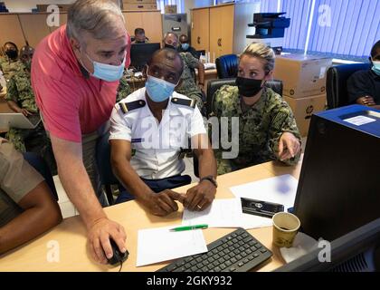 210727-N- TI693-1081    MOMBASA, Kenya (July 27, 2021) Dave Rollo, U.S. Naval Forces Africa maritime domain awareness program manager, left, demonstrates features of SeaVision for a Comoros Coast Guard officer, center, while Yeoman 1st Class Marley Schafer, assigned to U.S. Naval Forces Africa East Detachment 118, Denver, Colo., translates, during exercise Cutlass Express 2021, in Mombasa, Kenya, July 27, 2021. Cutlass Express is designed to improve regional cooperation, maritime domain awareness and information sharing practices to increase capabilities between the U.S., East African and West Stock Photo