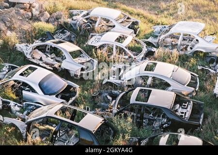 Top view of the car graveyard. Broken old rusty cars lying on the grass Stock Photo