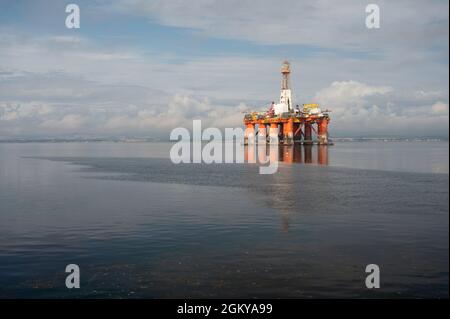 Floating orange and white oil rig in the Cromarty Firth. Sunny day with blue sky and clouds, no people. Lots of copy space. Stock Photo