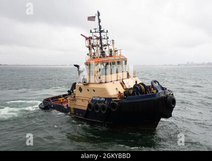 210727-N-LK647-0153 MONROVIA, Liberia (July 27, 2021) A Liberian tug boat approaches the Expeditionary Sea Base USS Hershel 'Woody' Williams (ESB 4) to transport personnel, July 27, 2021. Hershel 'Woody' Williams is on a scheduled deployment in the U.S. Sixth Fleet area of operations in support of U.S. national interests and security in Europe and Africa. Stock Photo