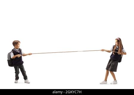 Full length profile shot of a schoolgirk and schoolboy pulling a rope isolated on white background Stock Photo