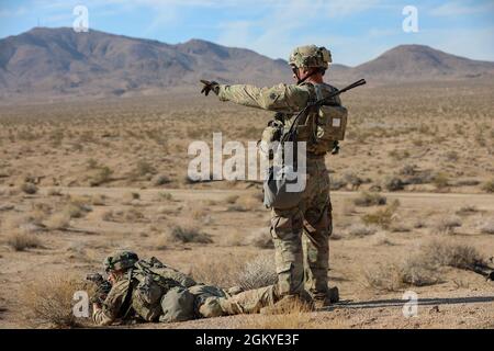 Soldiers with the 45th Infantry Brigade Combat Team, Oklahoma Army National Guard, move through the desert during a live-fire exercise at the National Training Center in Fort Irwin, California, July 24, 2021. Members of the 45th IBCT participated in a live fire exercise in the mountains of the Mojave Desert with the intention of increasing their proficiency. Stock Photo