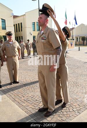 210728-N-OX321-1151 NAVAL AIR STATION SIGONELLA, Italy (July 28, 2021)— Senior Chief Aviation Boatswain’s Mate (Launch and Recovery Equipment) David Hooker is covered by Naval Air Station (NAS) Sigonella Command Master Chief Anna Wood during a senior chief petty officer pinning ceremony held onboard NAS Sigonella, July 28, 2021. NAS Sigonella’s strategic location enables U.S., allied, and partner nation forces to deploy and respond as required ensuring security and stability in Europe, Africa and Central Command. Stock Photo