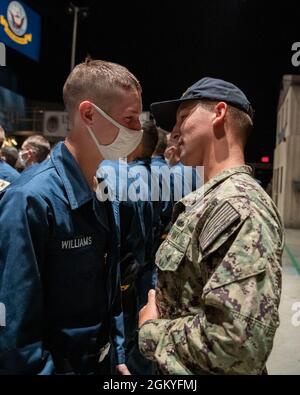 Aviation Ordnanceman 2nd Class Zachary Williams congratulates his brother, Seaman Recruit Caleb Williams, during his capping ceremony inside USS Trayer at Recruit Training Command. Trayer, more commonly referred to as 'Battle Stations,' is the crucible event that recruits must pass prior to graduation, testing their knowledge and skills in basic seamanship, damage control, firefighting and emergency response procedures. More than 40,000 recruits train annually at the Navy's only boot camp. Stock Photo