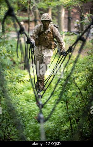 A U.S. Marine Corps officer candidate with India Company navigates through the Combat Course at Officer Candidates School on Marine Corps Base Quantico, Virginia, July 29, 2021. The Combat Course simulates an environment that may be encountered on the battlefield. During the course, candidates are evaluated in individual tactics while negotiating obstacles. Stock Photo