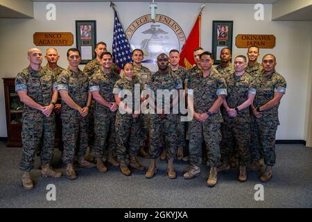 Staff noncommissioned officers attending the Advanced Course at the Camp Hansen Staff Noncommissioned Officer Academy (SNCOA) pose for a group photo on Camp Hansen, Okinawa, Japan, July 29, 2021. Using predictive analytical tools, critical decision making, and feasibility of support, students attending the Advanced School at the SNCOA used a littoral war game to combine their diverse backgrounds and simulate various sea-based operations and strategies. Stock Photo