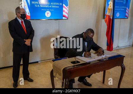 With Secretary of Foreign Affairs Teodoro Locsin Jr. looking on, Secretary of Defense Lloyd J. Austin III signs a guestbook at the Philippine Ministry of Foreign Affairs, July 30, 2021. Austin is on a week-long trip to reaffirm defense relationships and conduct bilateral meetings with senior officials in Vietnam, Singapore and Manila, Philippines. Stock Photo