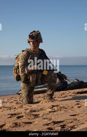 A British Royal Marine, with 40 Commando, post security during an amphibious landing with U.S. Marines with 1st Battalion, 7th Marine Regiment, Japanese Ground Self Defense Force soldiers, and Australian Army soldiers with 3rd Royal Australian Regiment during Exercise Talisman Sabre 21 in Ingham, Queensland, Australia, July 30, 2021. Amphibious operations provide a Combined-Joint Force Commander the capability to rapidly project power ashore in support of crisis response at the desired time and location. TS21 supports the Indo-Pacific Pathways initiative to advance a free and open Indo-Pacific Stock Photo