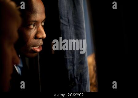 Personal aide Reggie Love peeks between the curtains at the Democratic ...