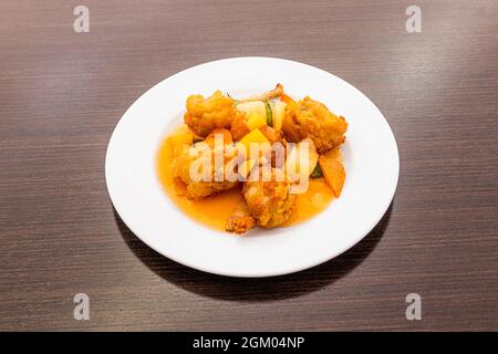 Crispy Battered Fried Chicken Thighs with Chinese Recipe Bittersweet Sauce and Seasonings on White Plate Stock Photo