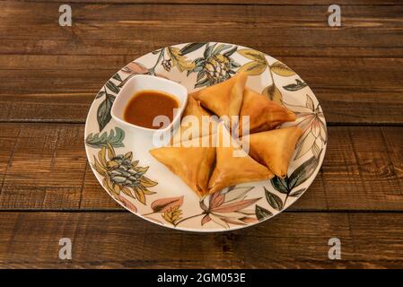 Porción de carne samosa cocida con receta oriental con salsa para mojar Stock Photo