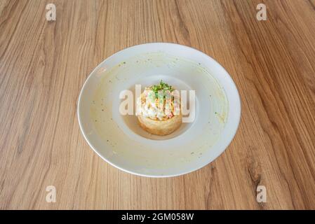 Typical Spanish tapa of Russian salad with parsley and mayonnaise on white plate Stock Photo