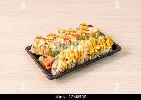 Uramaki dragon roll with prawns in tempura many sauce, crispy onion, wasabi and ginseng Stock Photo